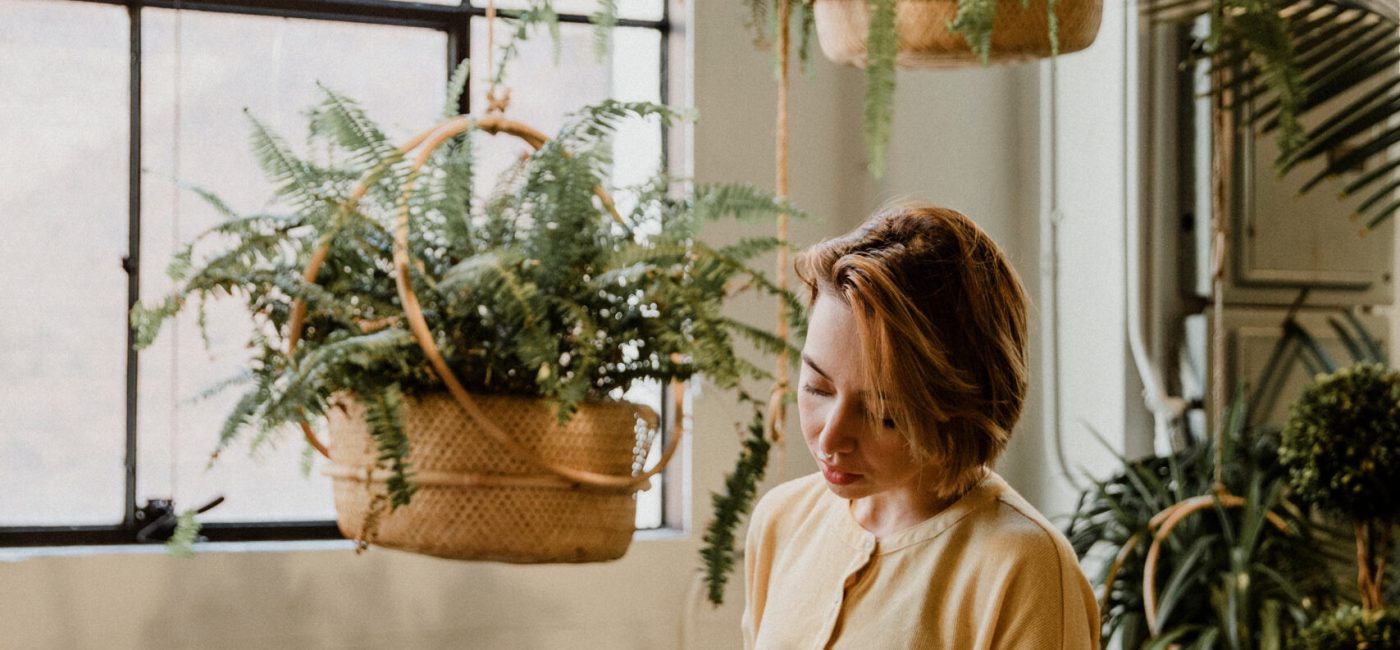 Woman taking care of her plants in a glasshouse